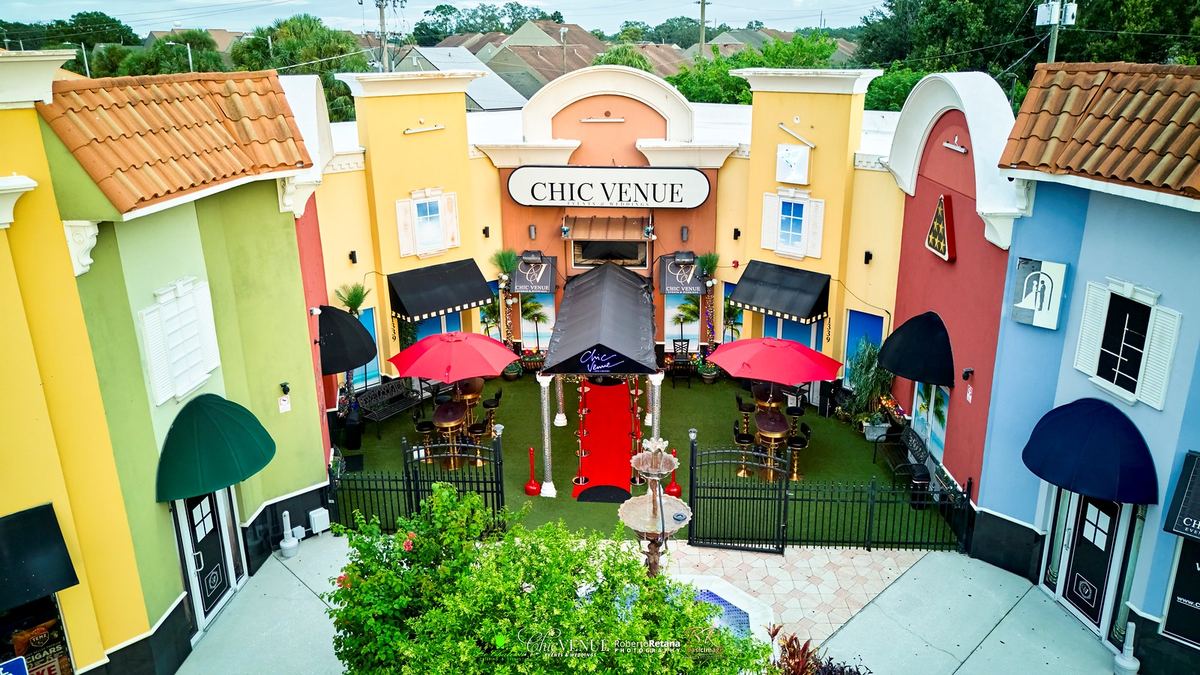 The Chic Venue courtyard entrance with fountain and red umbrellas